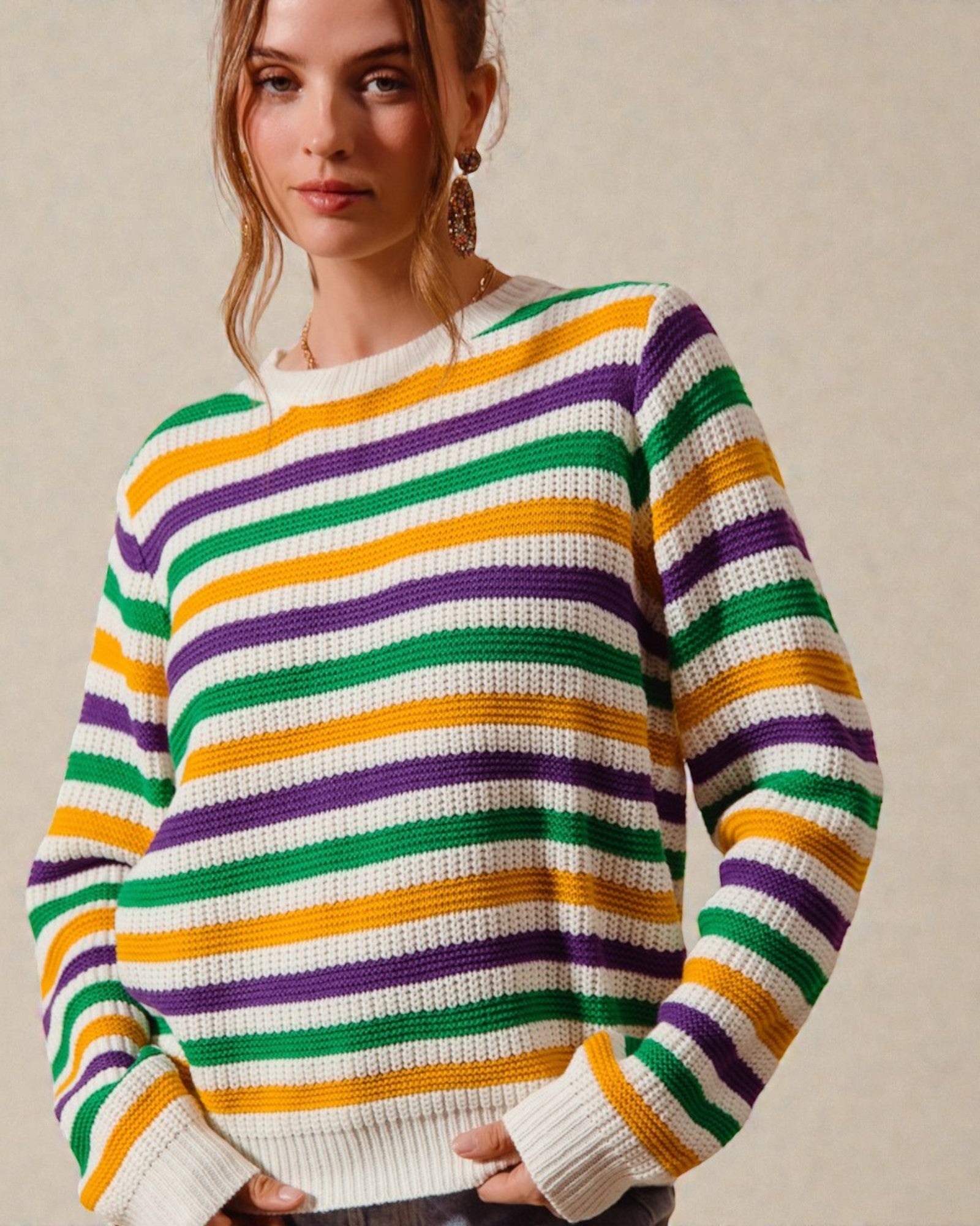 Woman wearing a colorful striped sweater against a plain background