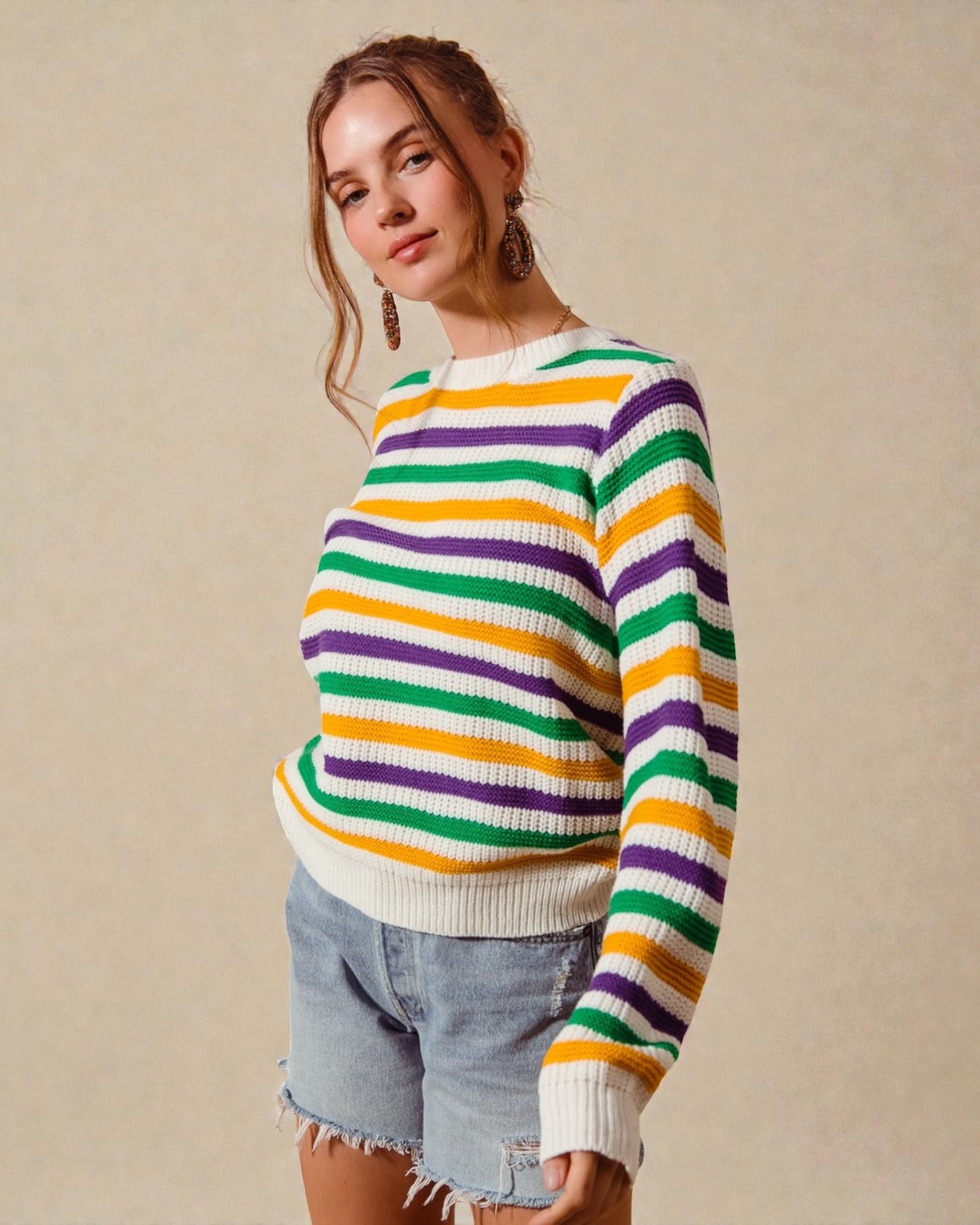 Woman wearing a colorful striped sweater against a beige background