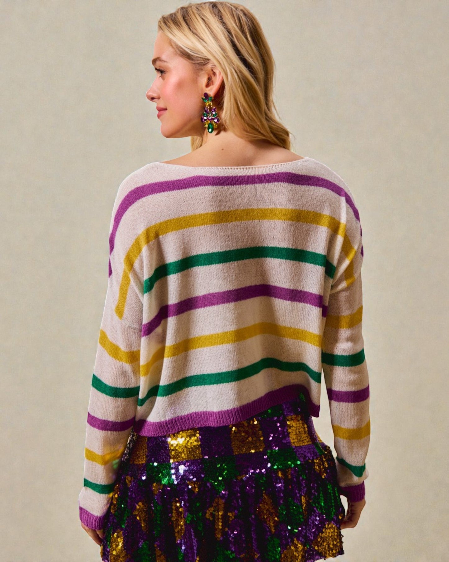 Person wearing a colorful striped sweater with a plain background