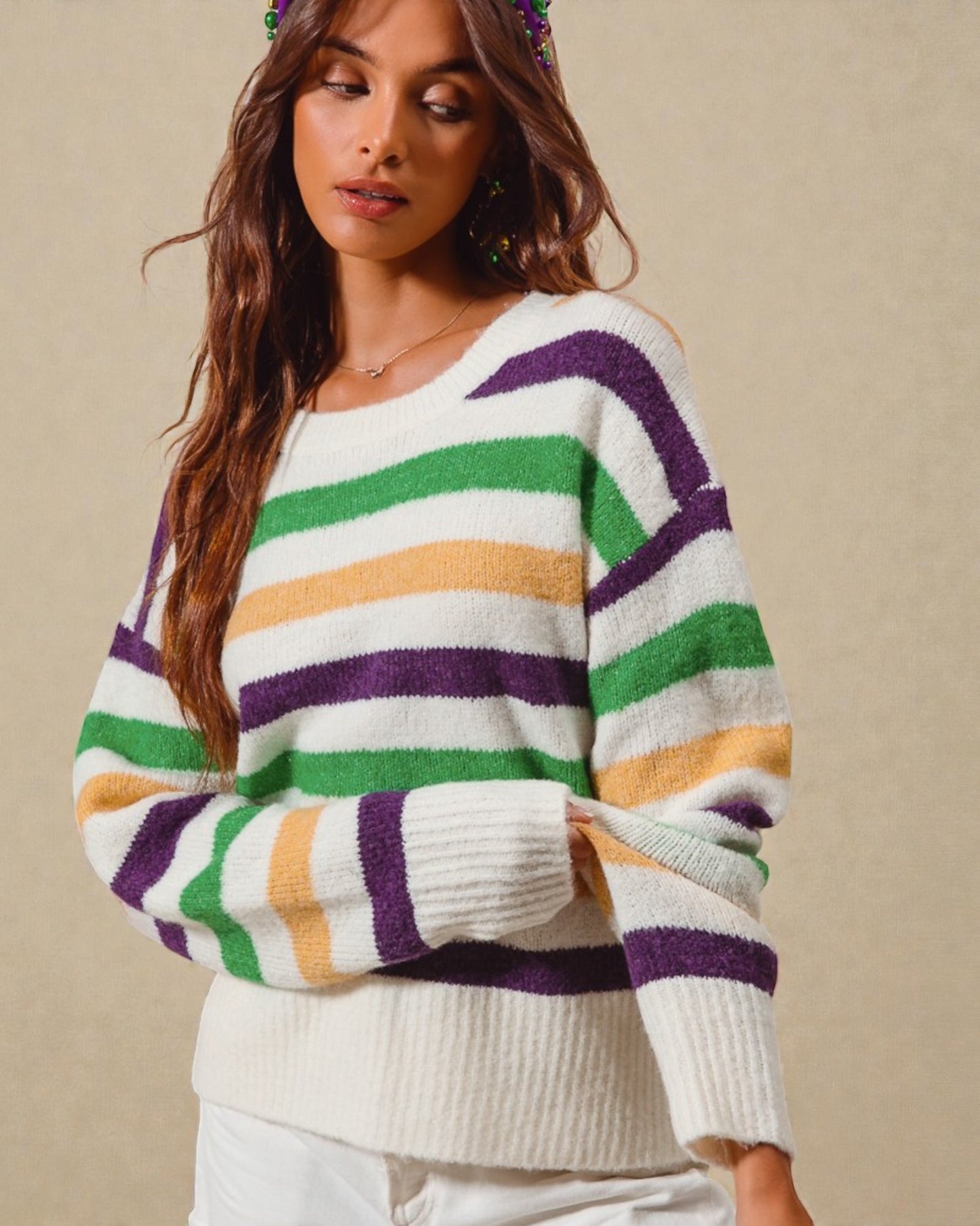 Woman wearing a colorful striped sweater against a beige background