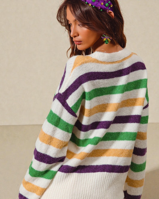 Woman wearing a colorful striped sweater with a neutral background