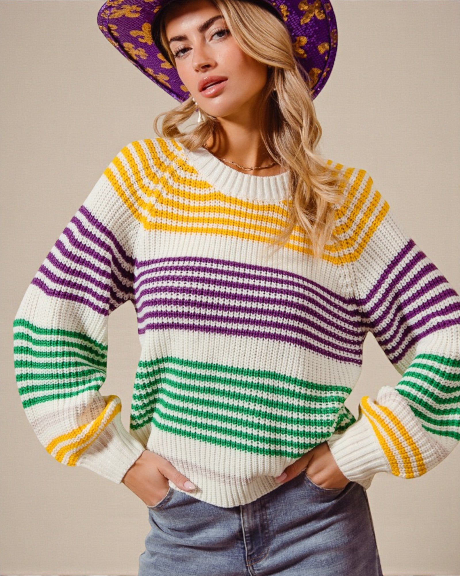Woman wearing a colorful striped sweater with a plain background