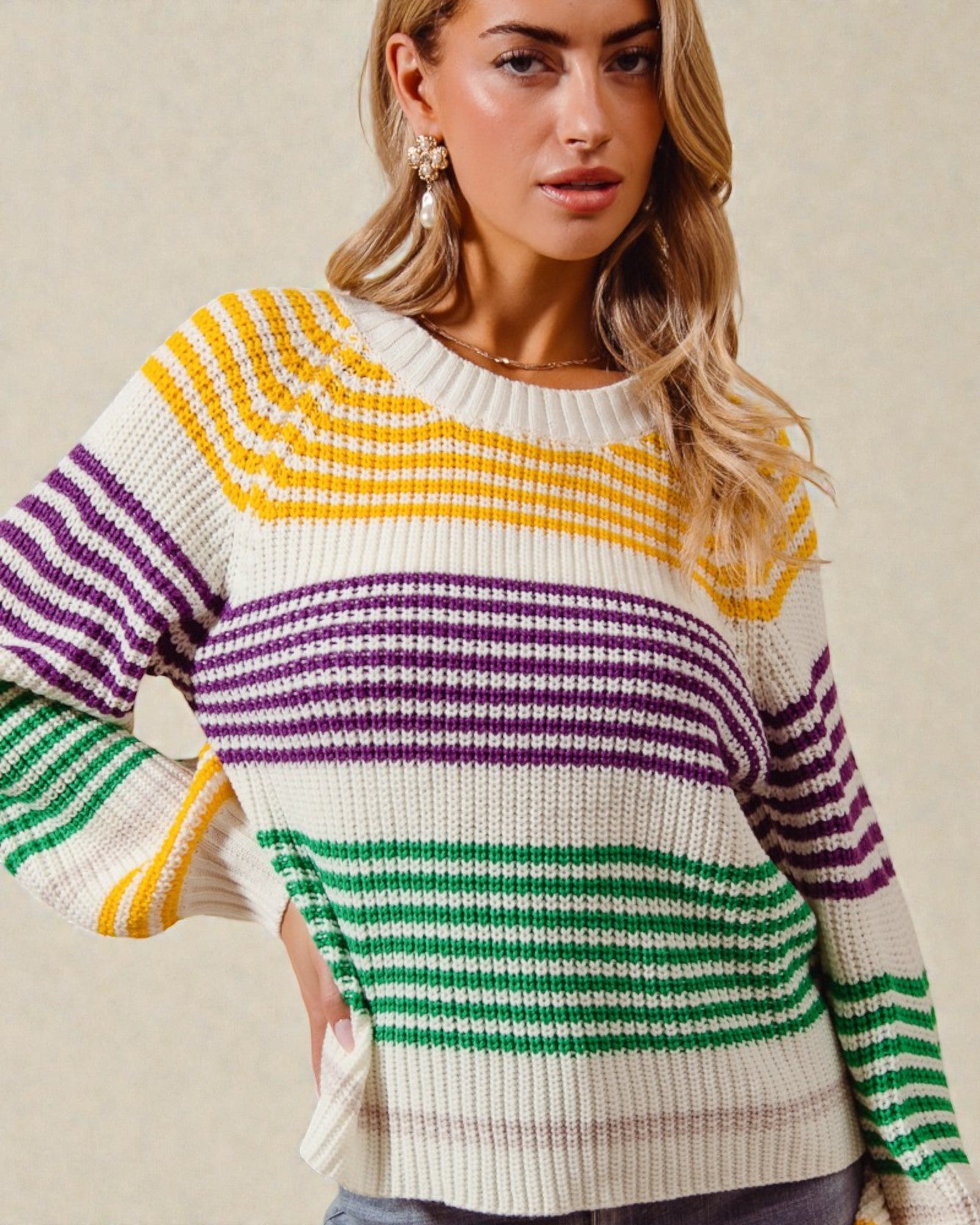 Woman wearing a colorful striped sweater against a neutral background