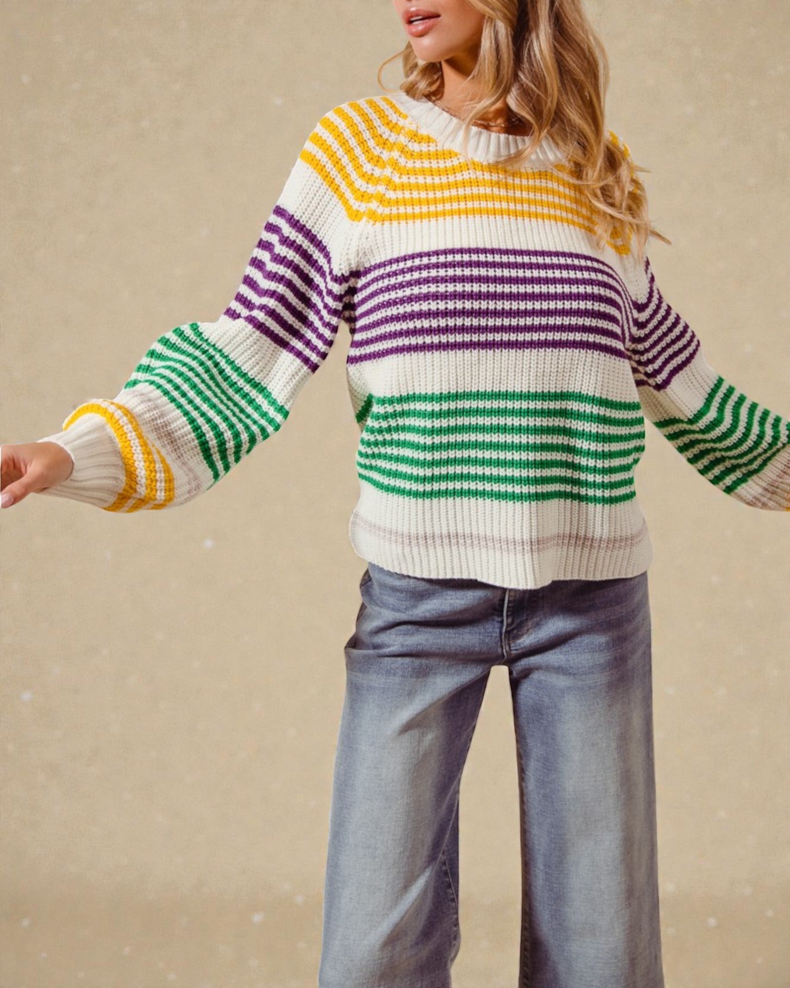 Person wearing a colorful striped sweater with a beige background