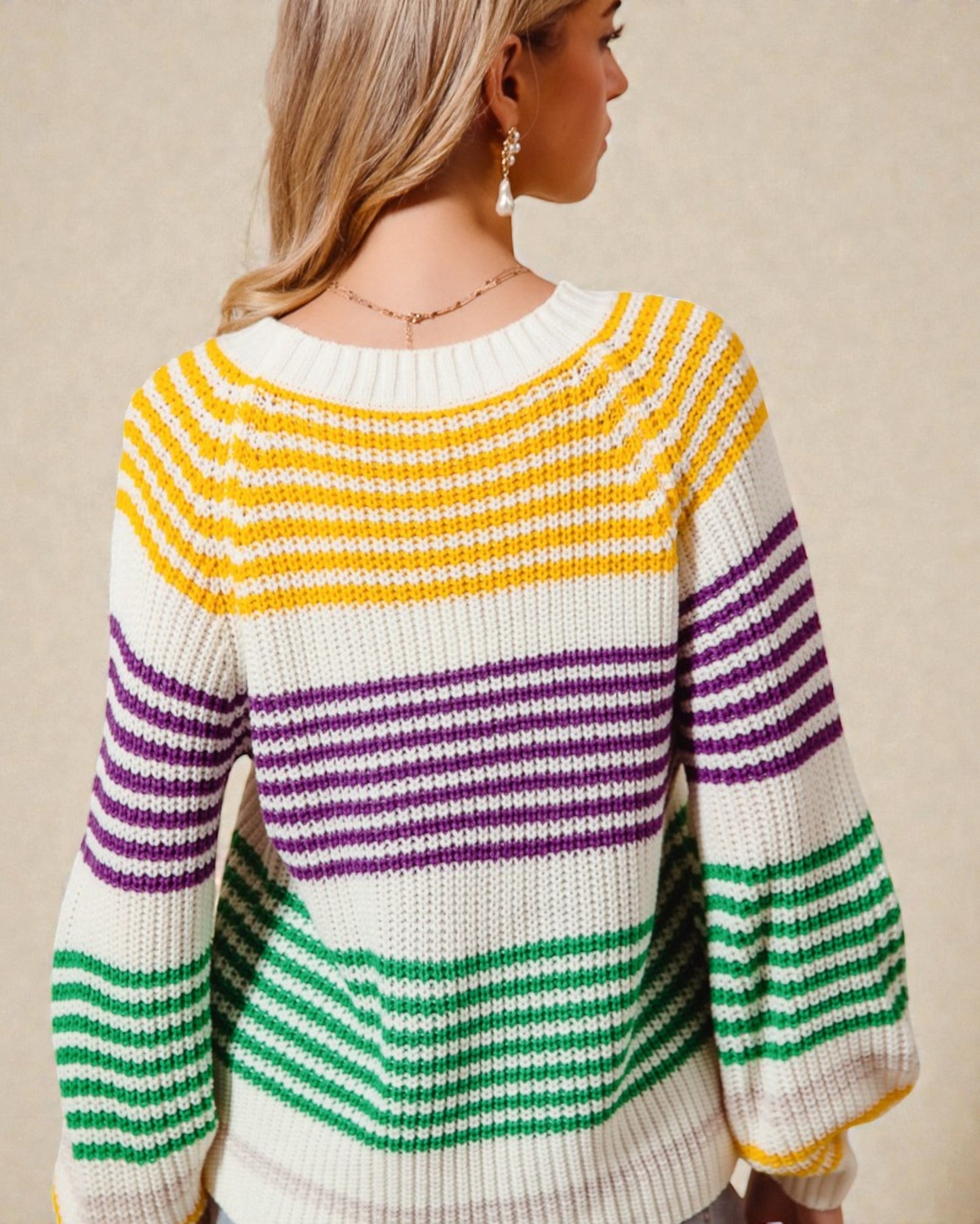 Woman wearing a colorful striped sweater on a beige background