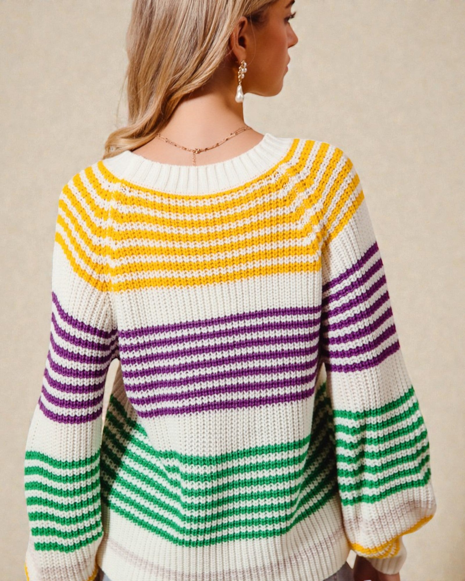 Woman wearing a colorful striped sweater on a beige background