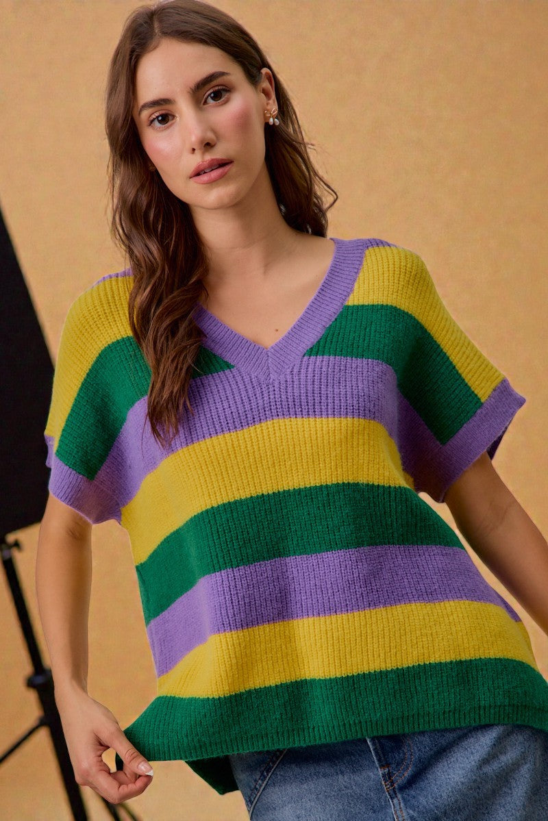 Woman wearing a colorful striped sweater against a beige background