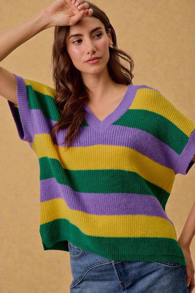 Woman wearing a colorful striped sweater against a beige background
