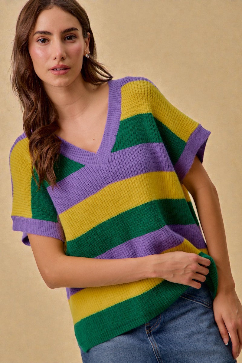 Woman wearing a colorful striped sweater against a beige background