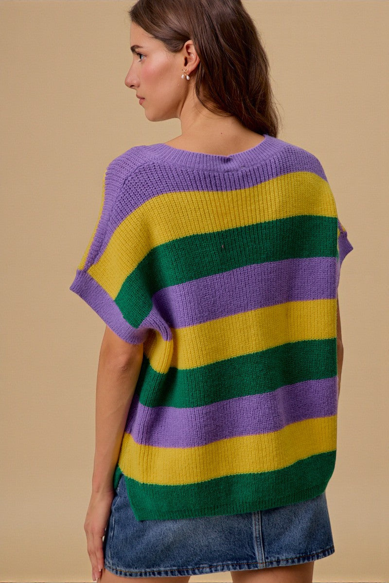 Woman wearing a colorful striped sweater against a beige background