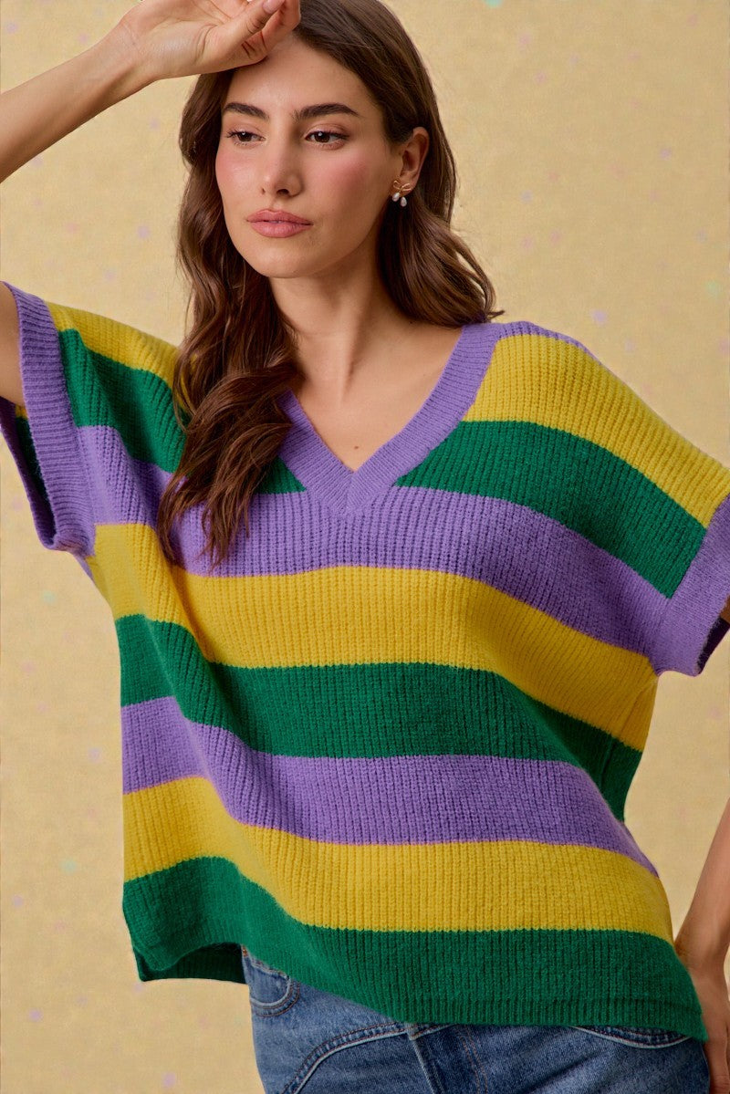 Woman wearing a colorful striped sweater against a yellow background