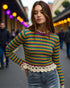 Woman wearing a colorful striped sweater with a blurred street background
