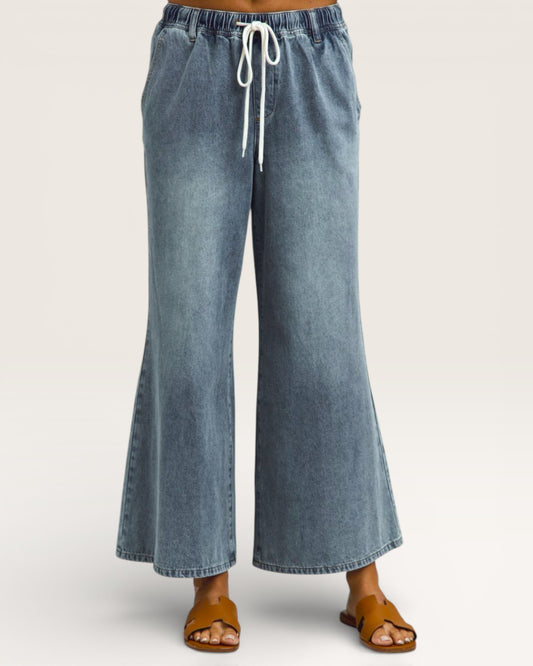 Blue denim wide-leg pants with a drawstring waist on a white background