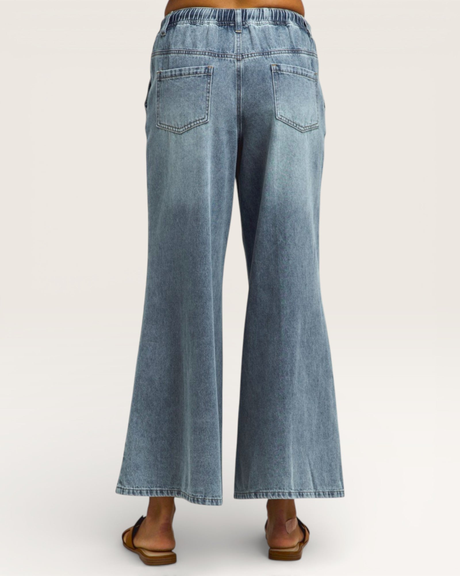 Blue jeans being worn on a white background