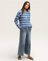 Woman wearing a blue striped sweater and jeans on a white background