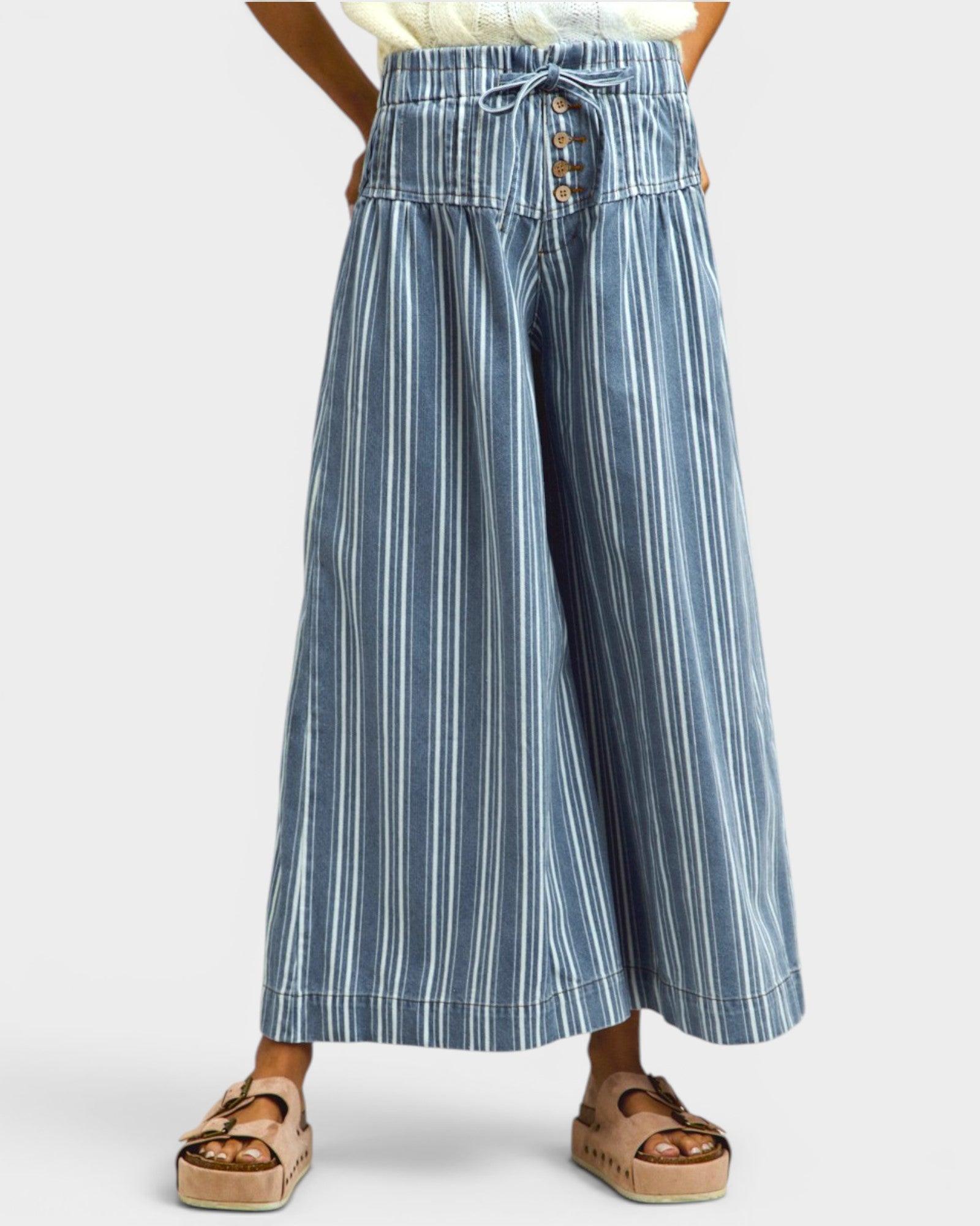 Blue and white striped wide-leg pants worn by a person on a white background