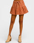 Brown denim skirt worn by a person on a white background