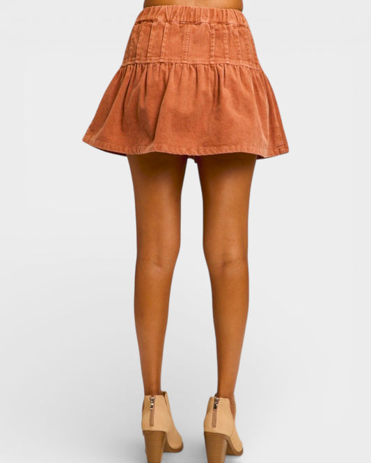 Person wearing a rust-colored skirt on a white background