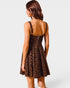 Woman wearing a leopard print dress on a white background