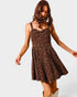 Woman wearing a leopard print dress on a plain background