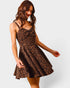 Woman wearing a leopard print dress on a plain background