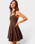 Woman wearing a leopard print dress against a white background