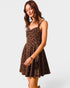 Woman wearing a leopard print dress on a plain background