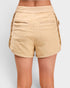 Beige shorts worn by a person on a light gray background