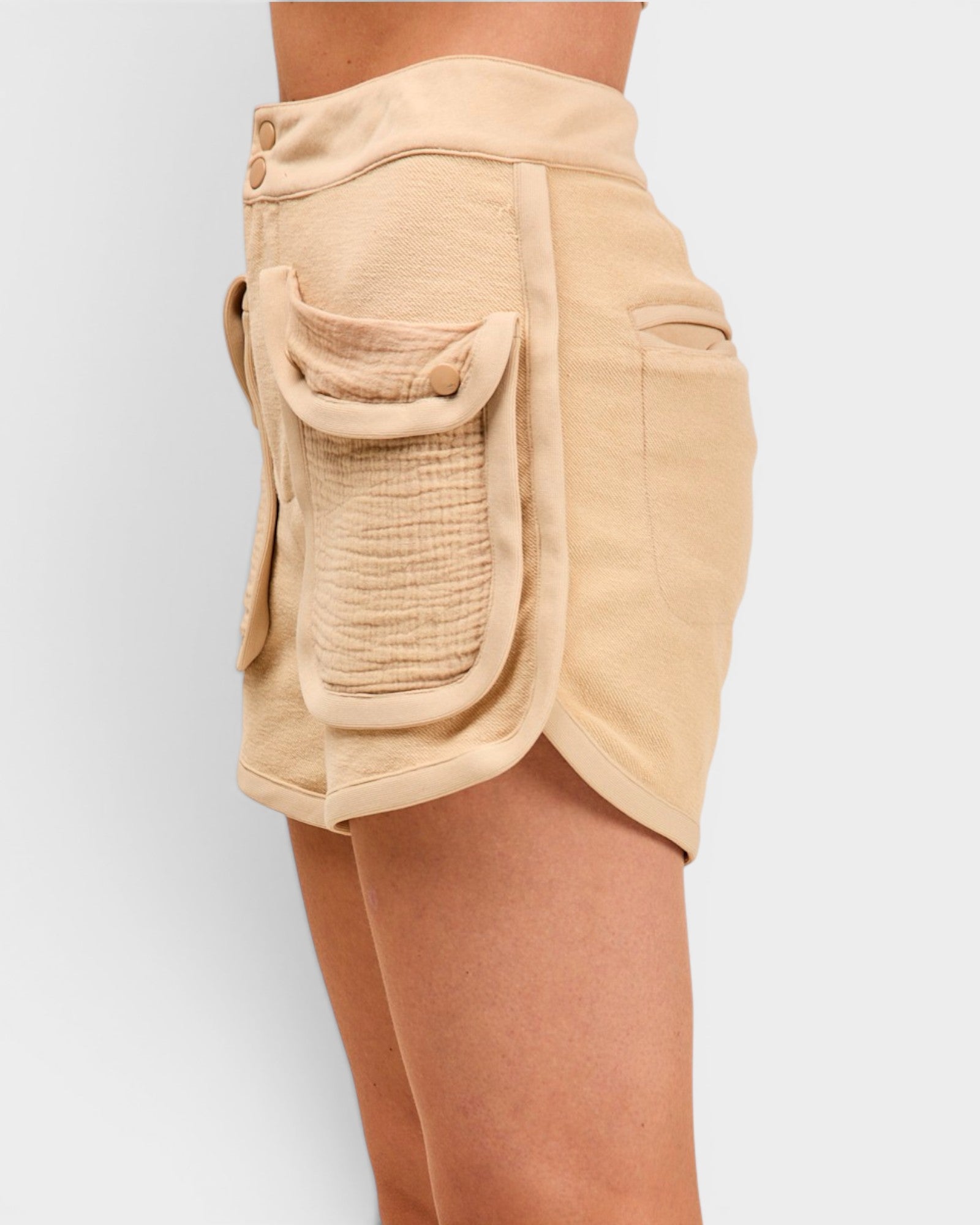 Beige skirt with textured pockets on a plain background