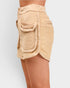 Beige skirt with textured pockets on a plain background
