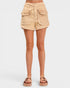 Beige shorts worn by a person on a white background