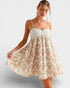 Woman wearing a floral dress on a plain background