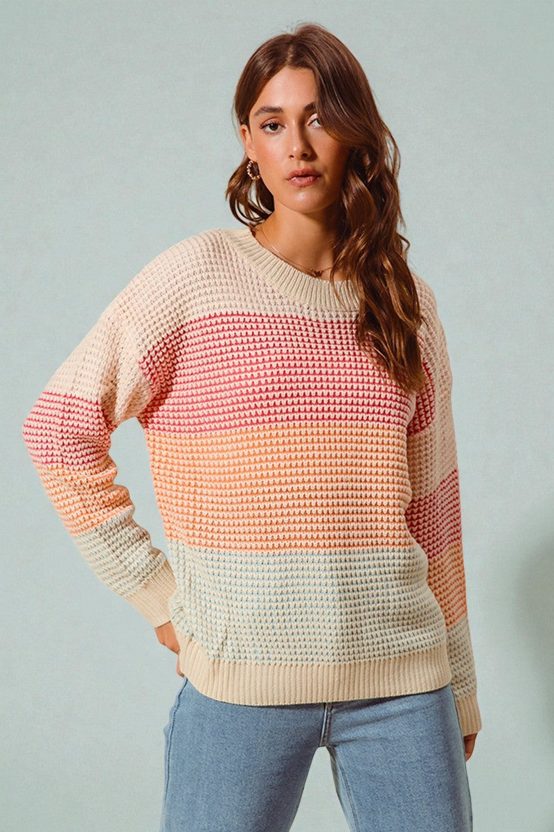 Woman wearing a colorful striped sweater against a plain background