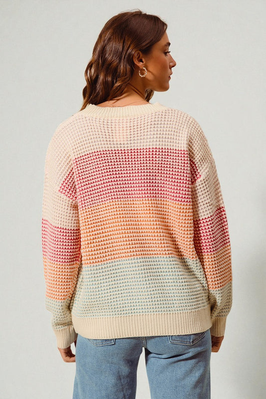 Person wearing a colorful striped sweater with a neutral background