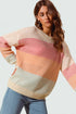 Woman wearing a colorful striped sweater against a plain background