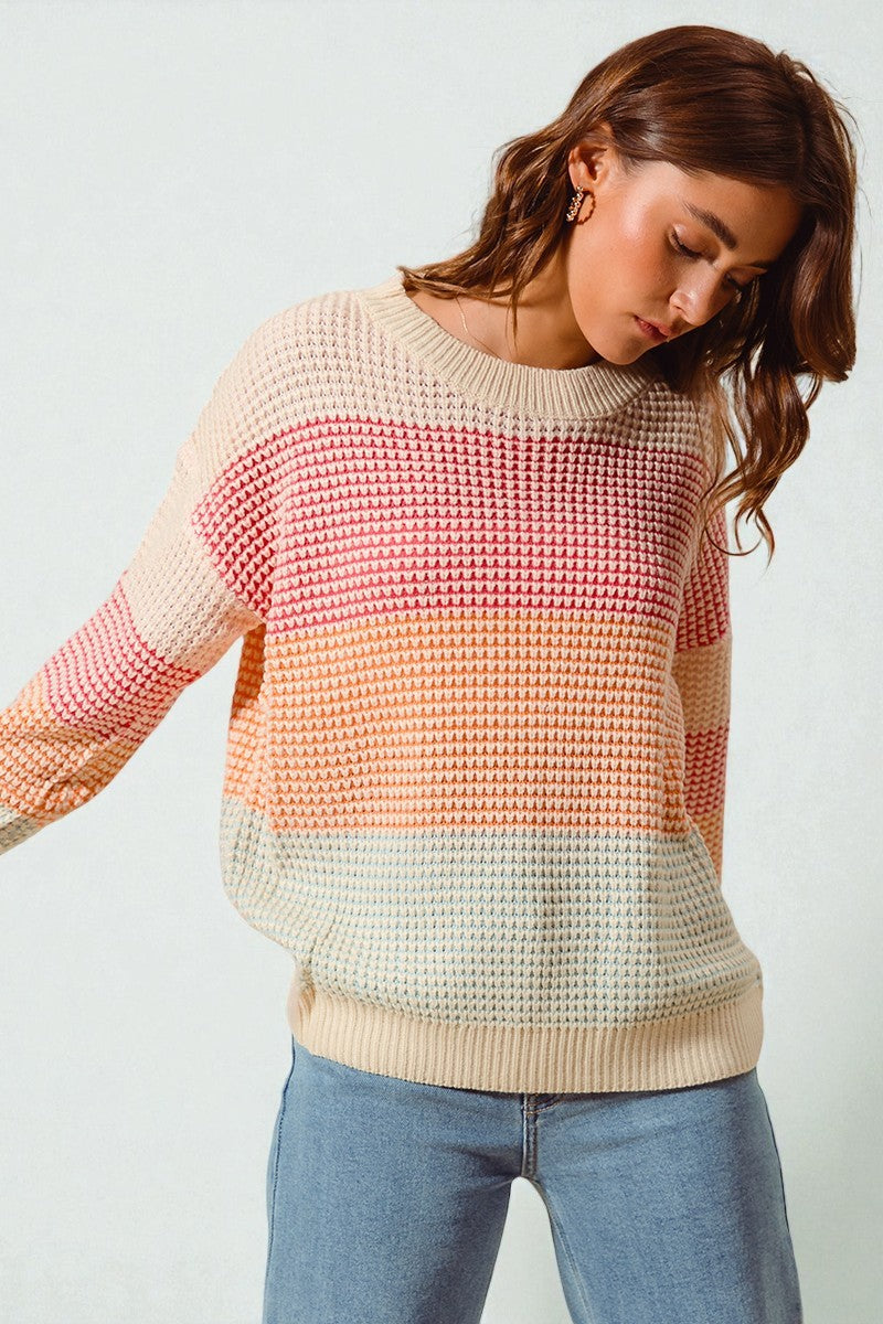 Woman wearing a colorful sweater with a white background