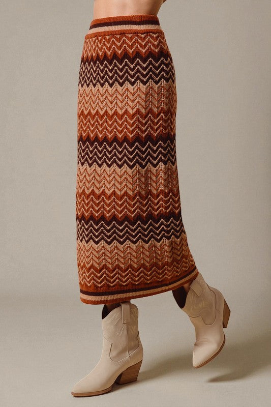Person wearing a patterned skirt and boots on a neutral background