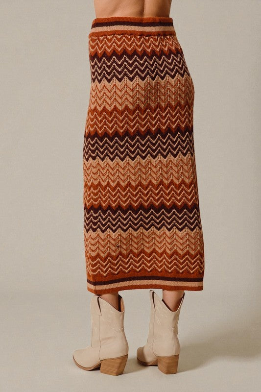 Person wearing a patterned skirt with beige boots on a neutral background