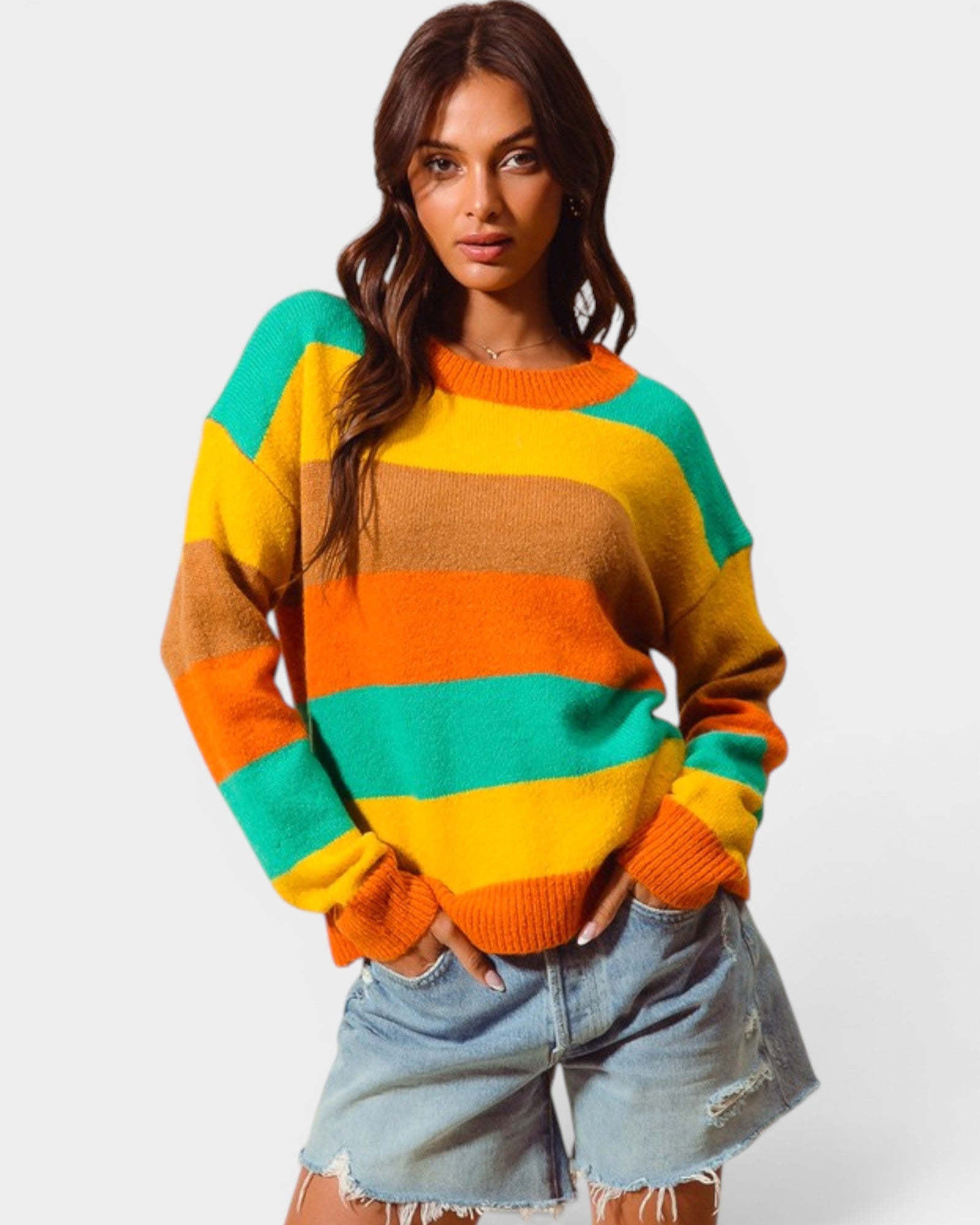 Woman wearing a colorful striped sweater with a plain background