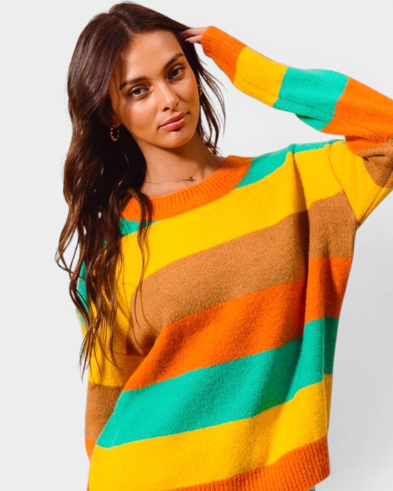 Woman wearing a colorful striped sweater against a plain background