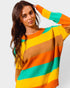 Woman wearing a colorful striped sweater against a plain background