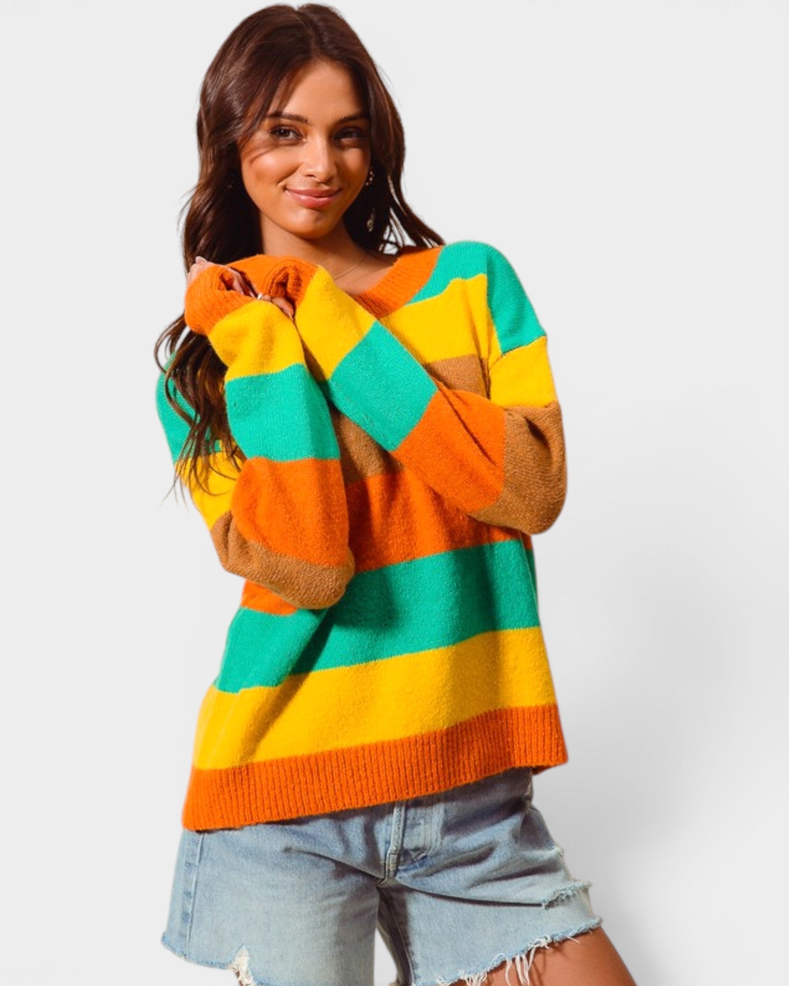 Woman wearing a colorful striped sweater on a white background