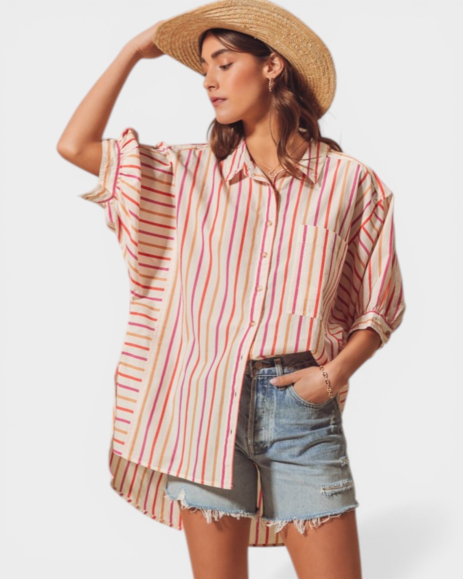 Woman wearing a striped shirt and denim shorts with a straw hat on a white background