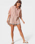 Woman wearing a striped shirt and shorts on a white background