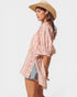Woman wearing a striped shirt and straw hat on a white background