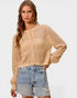 Woman wearing a beige cardigan and denim shorts on a white background