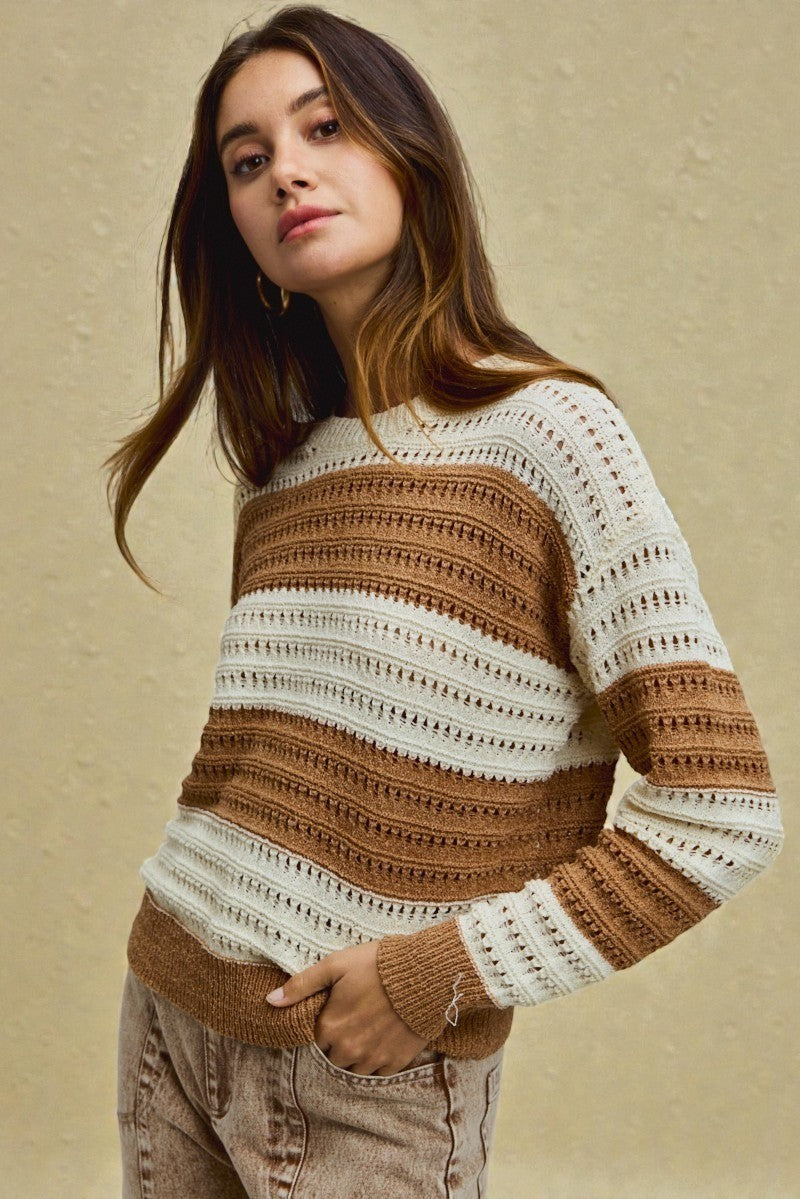 Woman wearing a striped sweater against a beige background