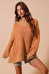 Woman wearing an orange knit dress against a beige background
