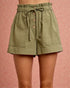 Green shorts with button details on a pink background