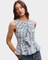 Woman wearing a blue plaid top with ruffle details on a white background